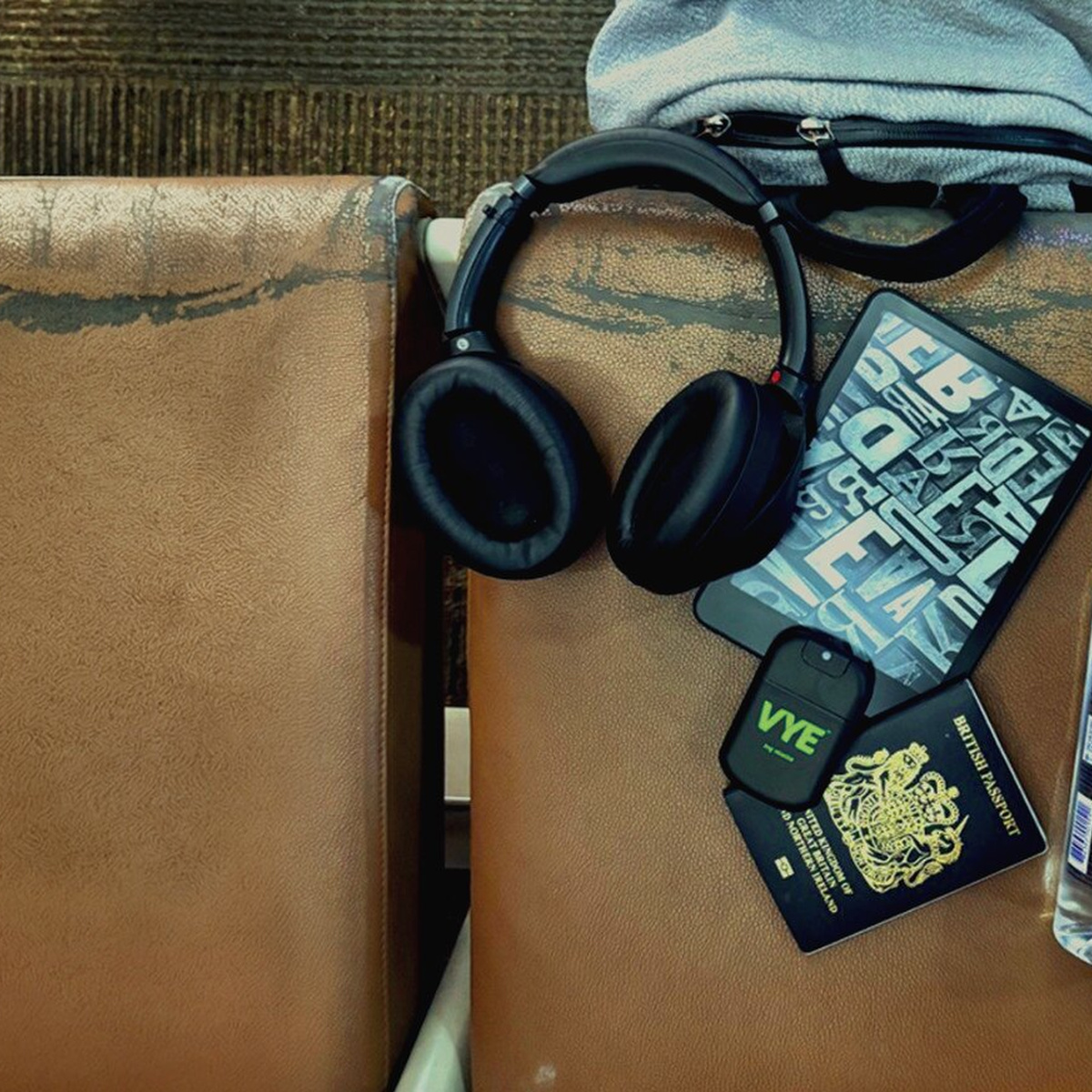 VYE mist alongside headphones and travel essentials